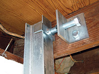 Securing the i-beam system to the top of the floor joist in a foundation wall repair in Downingtown.