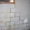 A cracked foundation wall near a window