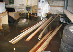 A severely flooding basement in Owings Mills, with lumber and personal items floating in a foot of water