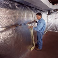 Installation of a radiant heat and vapor barrier on a basement wall in Villanova