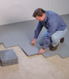 Contractors installing basement subfloor tiles and matting on a concrete basement floor in Parkville, Pennsylvania, Delaware, and Maryland